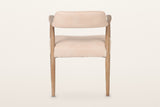 Back of the Laigueglia dining armchair in Beige leather on a warm white studio backdrop: the band is covered on the back too
