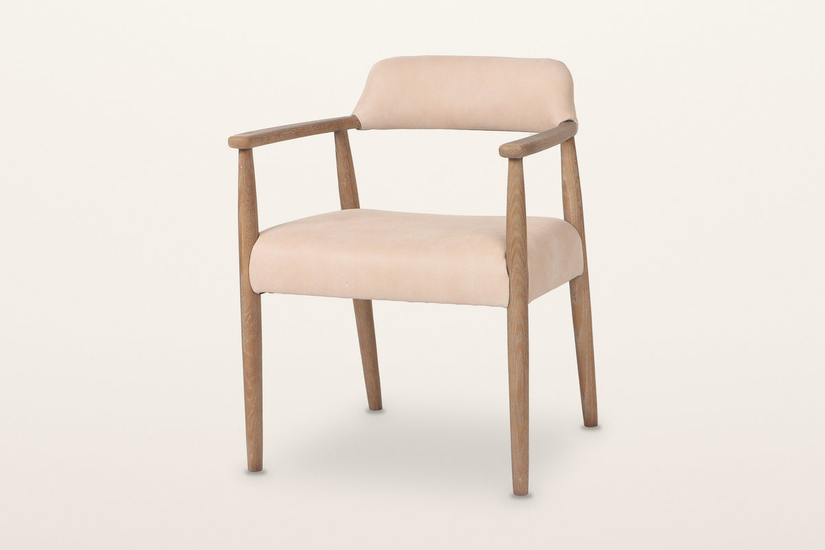 Laigueglia dining armchair in Beige leather, three-quarter view on a warm white studio backdrop: a low curved back band