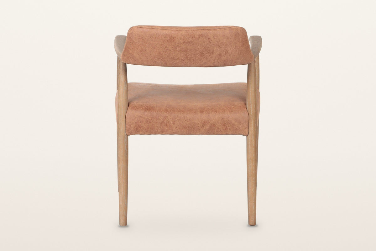 Back of the Laigueglia dining armchair in Brown leather on a warm white studio backdrop