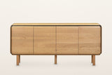 Larino sideboard in Natural and Black, straight front view on a warm white studio backdrop: four equal oak doors with rounded
