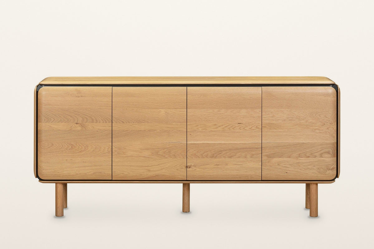 Larino sideboard in Natural and Black, straight front view on a warm white studio backdrop: four equal oak doors with rounded