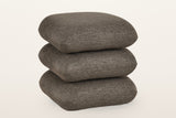 Lavagna square ottoman in Brown, three-quarter view on a warm white studio backdrop: three soft square pillows stacked