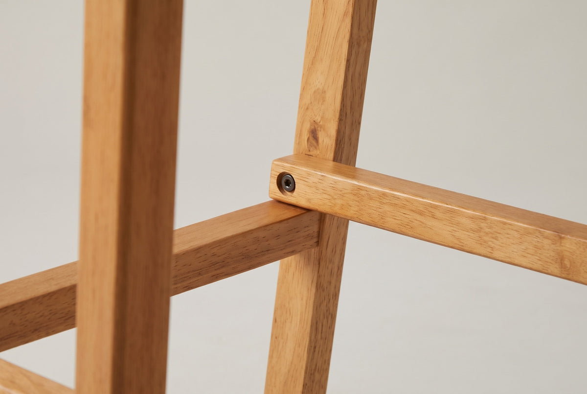 Close-up of a square wooden leg and the footrest rails of the Lazise stool, joined with a recessed bolt