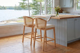 Two Lazise counter stools at a butcher-block island in a Muskoka cottage kitchen with a window onto the lake