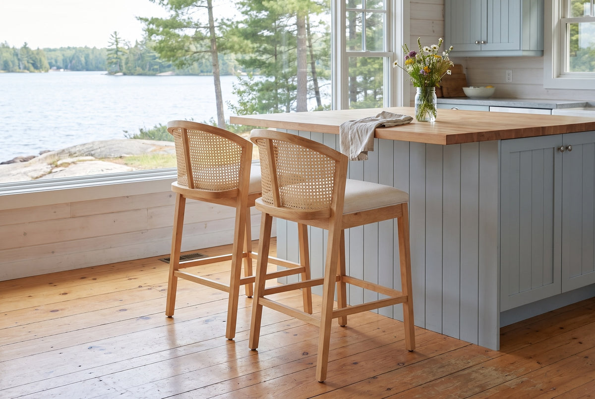 Two Lazise counter stools at a butcher-block island in a Muskoka cottage kitchen with a window onto the lake