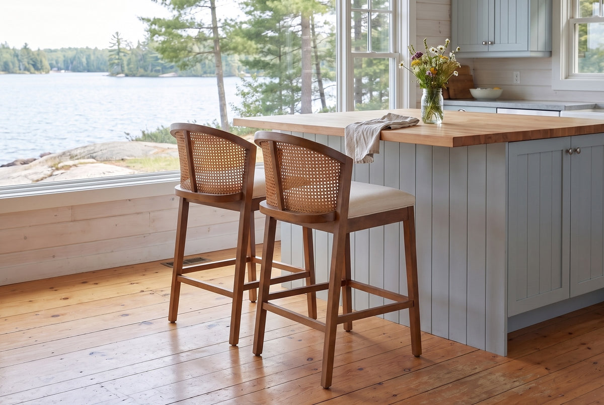 Two Lazise counter stools in the Walnut finish at a butcher-block island in a Muskoka cottage kitchen with a window onto