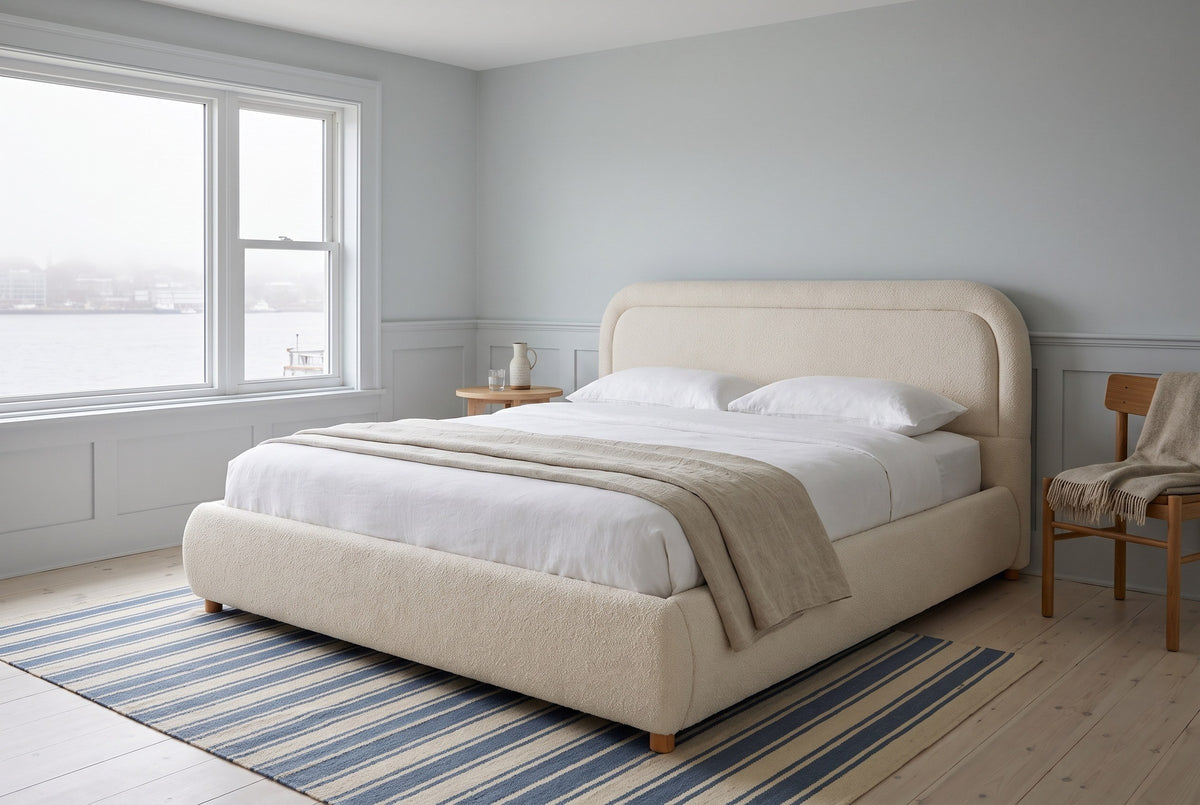 Lerici boucle bed in a pale blue bedroom with wainscoting, a harbour view and a striped rug