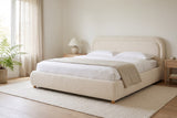 Lerici boucle bed made up with white linen in a bright bedroom with a fern, sheer curtains and pale oak nightstands