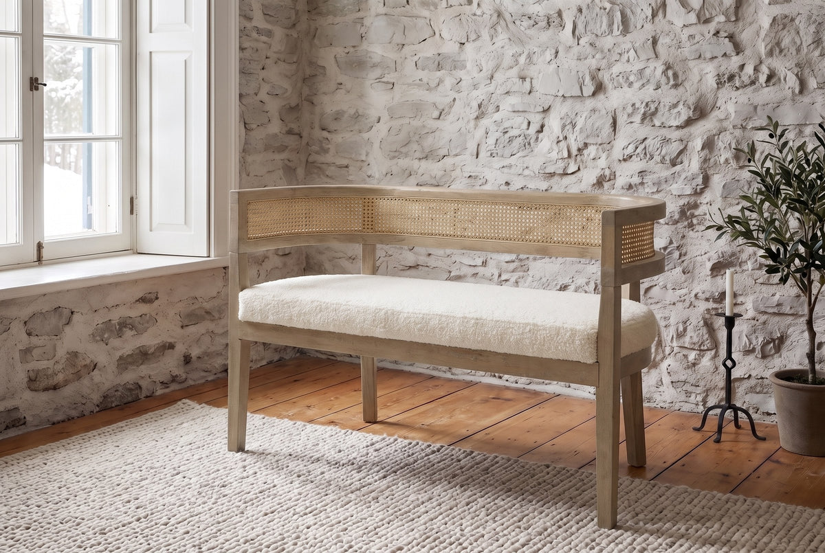 Levanto loveseat in beige boucle and natural ash against a fieldstone wall in a Quebec City living room in winter light