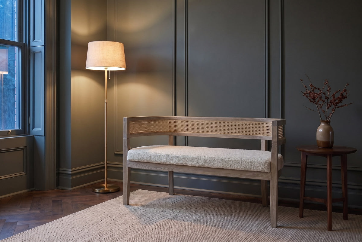 Levanto loveseat in beige boucle and natural ash against a green-grey panelled wall in a Toronto townhouse at dusk, a brass floor lamp lit beside it
