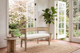 Levanto loveseat in beige boucle and natural ash in a Victoria garden room with open French doors, a flowering dogwood and a travertine side table