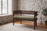 Levanto loveseat in green and walnut against a fieldstone wall in a Quebec City living room in winter light