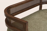 Close-up of the woven rattan band between its two walnut-finish rails, the squared arm end and the green seat pad