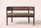 Levanto loveseat in green and walnut, straight front view: a woven rattan band wrapping the back and arms, one long seat pad and four square legs