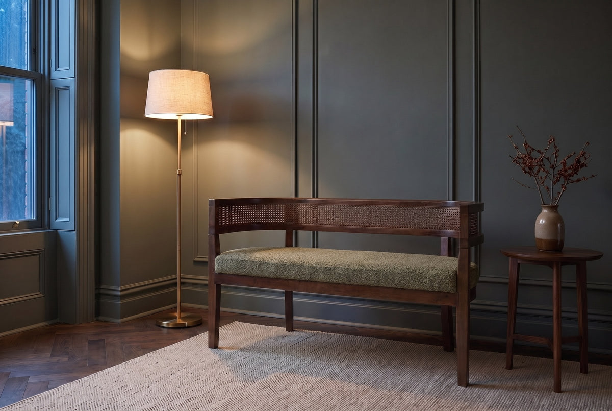 Levanto loveseat in green and walnut against a green-grey panelled wall in a Toronto townhouse at dusk, a brass floor lamp lit beside it