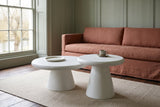 Levico white nesting coffee tables, nested, in front of a terracotta linen sofa in a sage-panelled Stratford sitting room