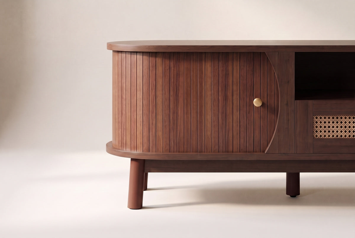 Close-up of one rounded end of the Livia console: the curved reeded walnut sliding door, its small round knob and two legs
