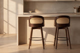 Two Locorotondo counter stools pulled out from a pale stone kitchen island in golden-hour light