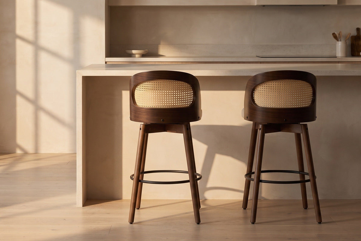 Two Locorotondo counter stools pulled out from a pale stone kitchen island in golden-hour light