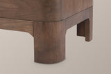 Close-up of a Lodi front leg in Brown Oak with its rounded face and the recessed apron meeting it in a curved cove