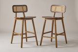 A pair of Lovere counter stools in Walnut, three-quarter view on a warm grey studio backdrop