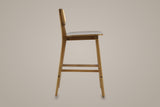Lovere counter stool in Walnut, side view showing the seat height and the footrest