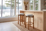 Two Lucera bar stools in Walnut on a jute runner at a pale pine counter by a lake window in a Muskoka cottage