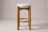 Lucera bar stool in Walnut, straight front view: thin round linen-look cushion, four square legs and a round footrest