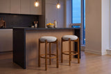 Two Lucera bar stools in Walnut at a stone-topped island with a white-oak front in a Toronto condo kitchen at dusk