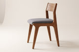 Lucrezia dining chair in the Walnut finish with a grey fabric seat, side three-quarter view on an off-white background