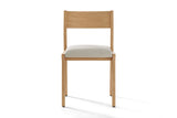 Lucrezia dining chair in the White Oak finish with an off-white fabric seat, seen from the front on a white background
