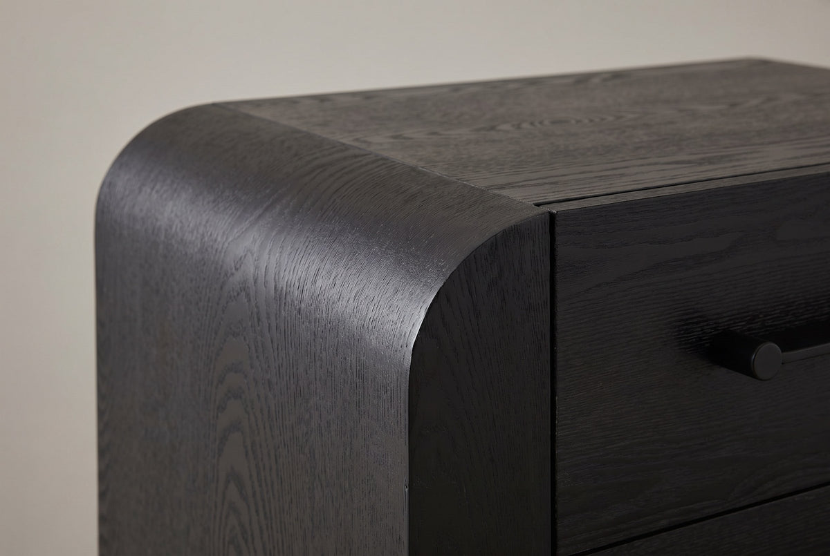 Close-up of the rounded waterfall corner, the seam to the flat top and the end of a black bar handle