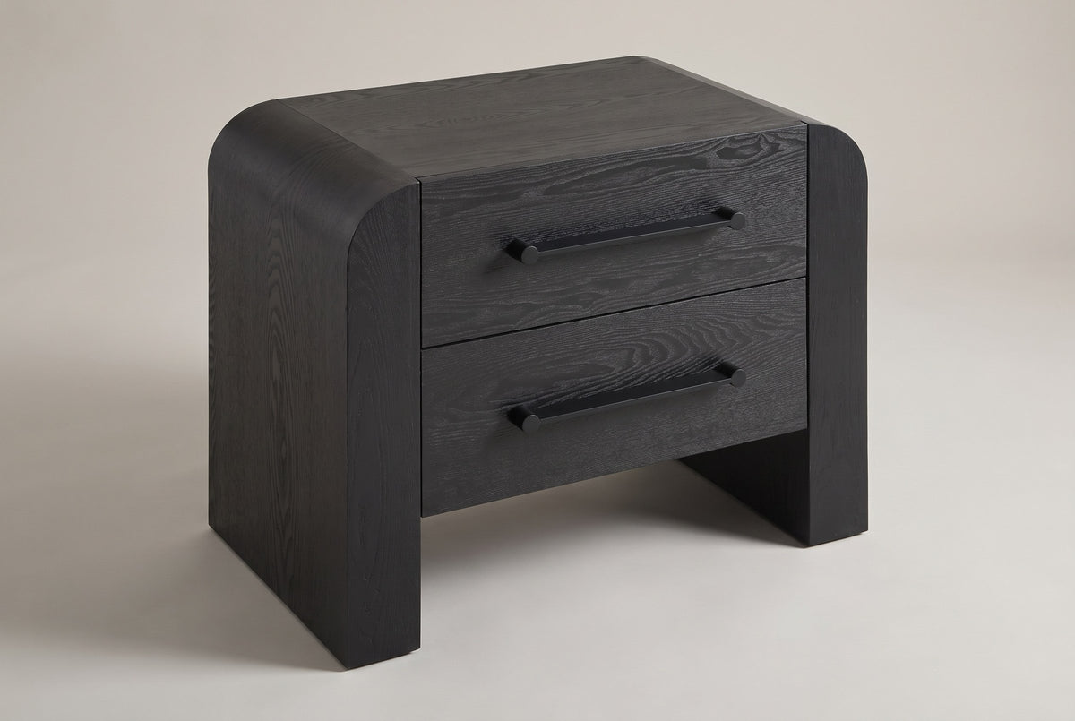 Macerata waterfall 2-drawer nightstand in black, three-quarter view on a warm grey studio backdrop