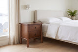 Malcesine nightstand beside a bed with white linen in a bright Halifax bedroom
