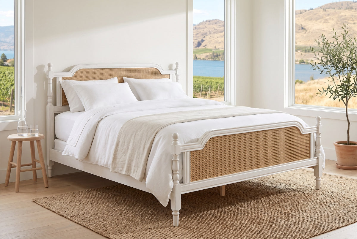 Manarola bed in a bright lake-house bedroom with vineyard and lake views, a seagrass rug and an olive tree