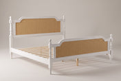 Manarola cane panel bed in antique white, three-quarter view on a warm light-grey studio backdrop