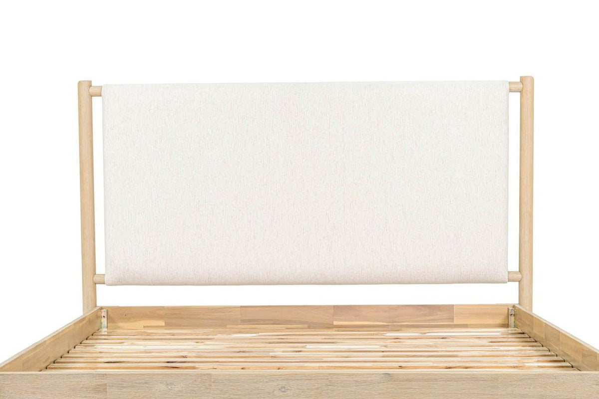 Close-up of the Manciano headboard: one off-white cushion hung between two round posts