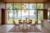 Marano round dining table in a Wolfville house, with walnut panelling, amber glass pendants