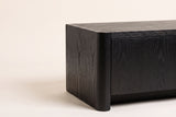 Close-up of a front top corner of the Maren cabinet in Black: the rounded corner post and the wood grain under the black stain