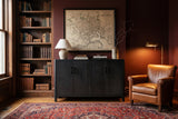 The Maren cabinet in Black below an antique map, in a Baltimore brownstone library with walnut bookshelves and a cognac leather chair