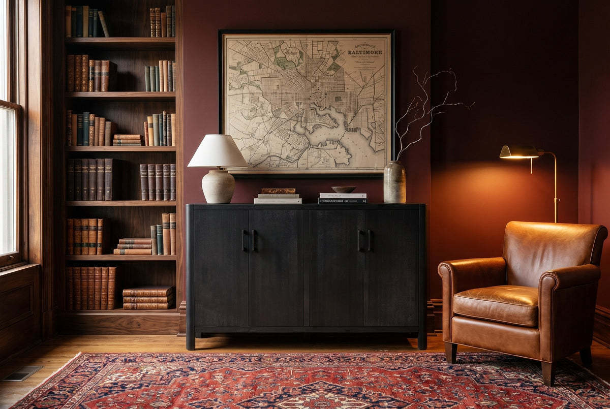 The Maren cabinet in Black below an antique map, in a Baltimore brownstone library with walnut bookshelves and a cognac leather chair