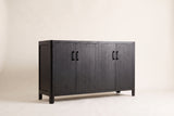 The Maren storage cabinet in Black, front three-quarter view: black-stained wood veneer doors with the grain showing, rounded corners and short legs, on an off-white studio background