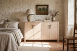 The Maren cabinet in Natural below a small painting of olive trees, in a lime-washed stone bedroom in the Luberon