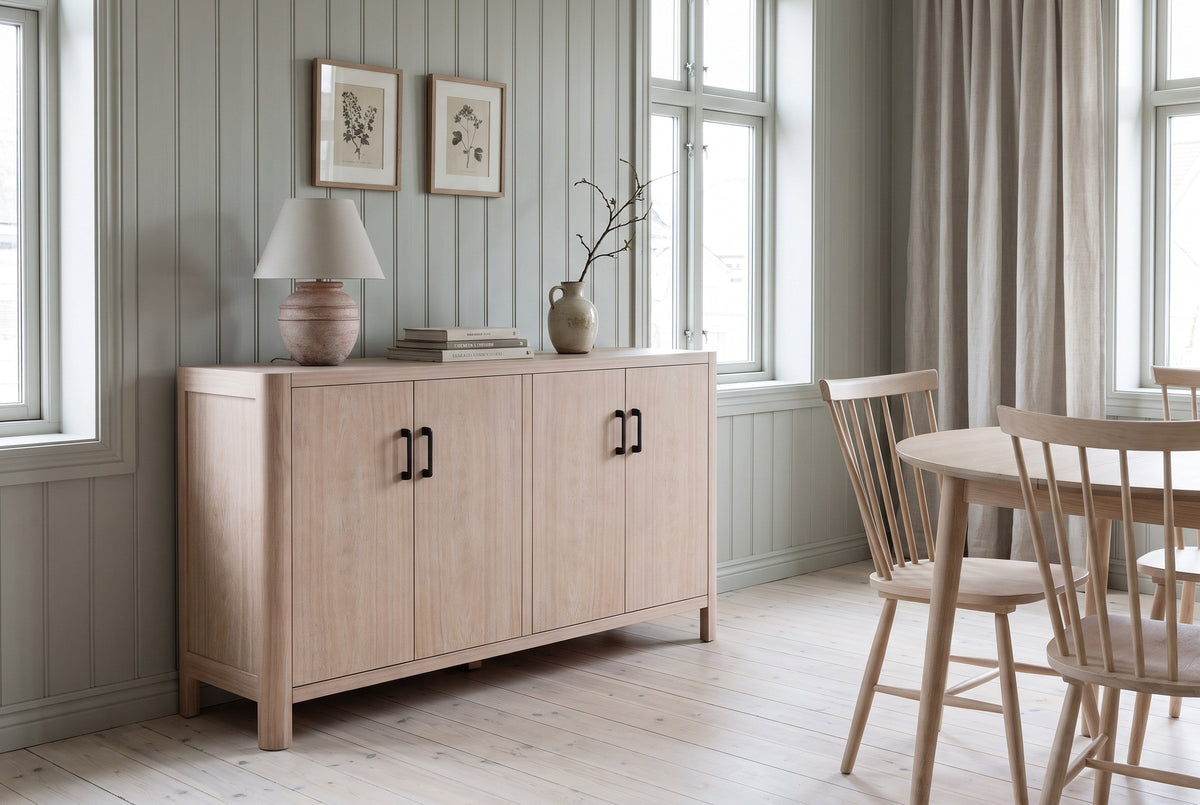 The Maren cabinet in Natural below two botanical prints, in a Trondheim dining room with grey-green painted panelling and a birch table