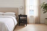 Marsala nightstand in Black beside a bed with white linen in a white shiplap Halifax bedroom with a harbour view