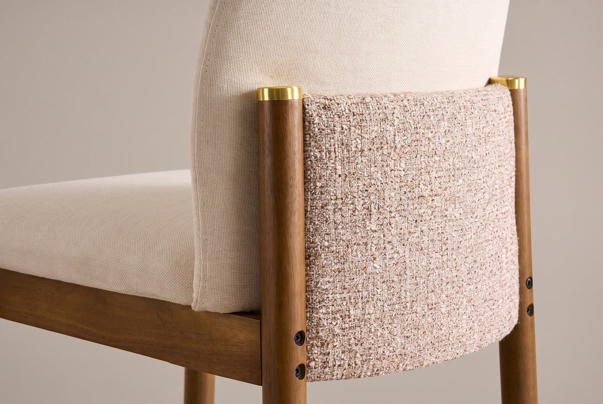 Close-up from behind of the Menaggio back: the textured oatmeal panel between two walnut posts with gold-tone caps