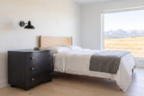 Merano nightstand in Black beside a bed in a white Calgary foothills bedroom with a view of the Rockies