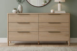 Merritt Sand oak dresser below a round mirror in a sage green bedroom