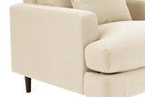 Close-up of the Mombaruzzo arm front with its fine welt, the seat cushion running past it and the base on a walnut brown leg