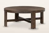Mondavio round coffee table in Smoked Acacia, three-quarter view on a warm white studio backdrop